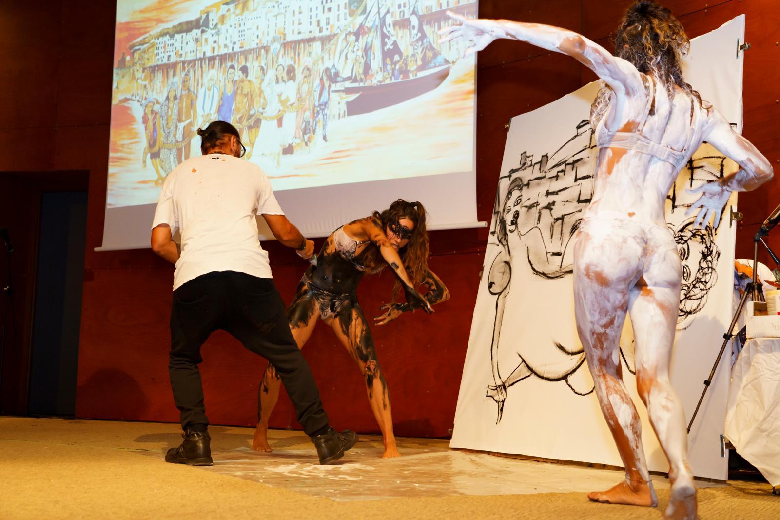 Live performance on stage: Behzad at the canvas with a dancer, projection behind